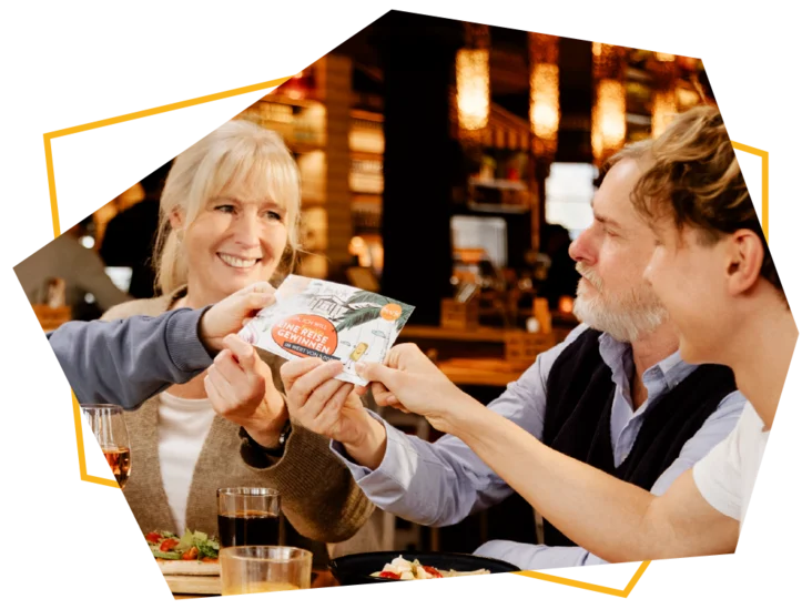 Lachende Familie mit einer Gewinnspiel-Karte in der Hand.  