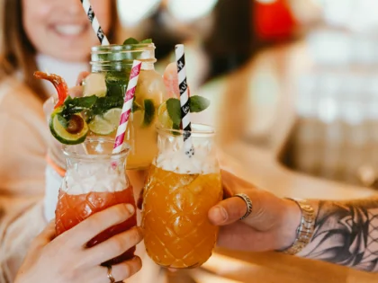 3 Menschen, welche mit Cocktaisl anstoßen