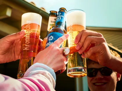 Freunde stoßen an mit frisch gezapften Krombacher, Krombacher Natur Radler und alkoholfreien Krombacher