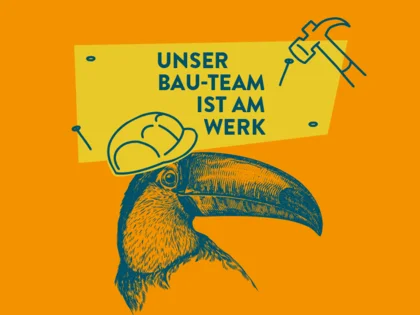 Eine orange-gelbe Grafik mit einem Tucan mit Helm und Hammer und Nägel. Darauf steht "Unser Bau-Team ist am Werk"