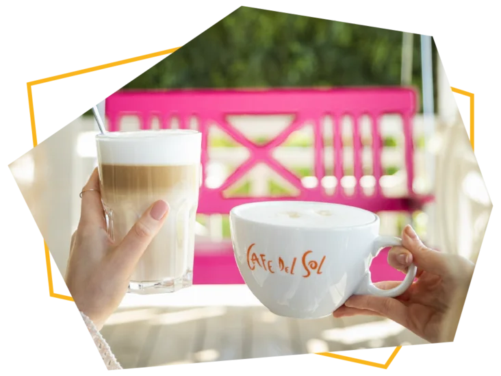 Ein Latte Macchiato und ein Milchkaffee im eckigen Rahmen vor der pinken Schaukel.