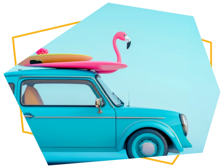Ein blaues Auto mit Surfbrettern und einem aufblasbaren Flamingo auf dem Dach.